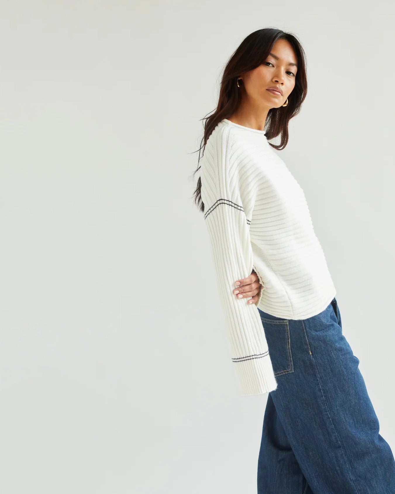 Woman wearing a white ribbed sweater