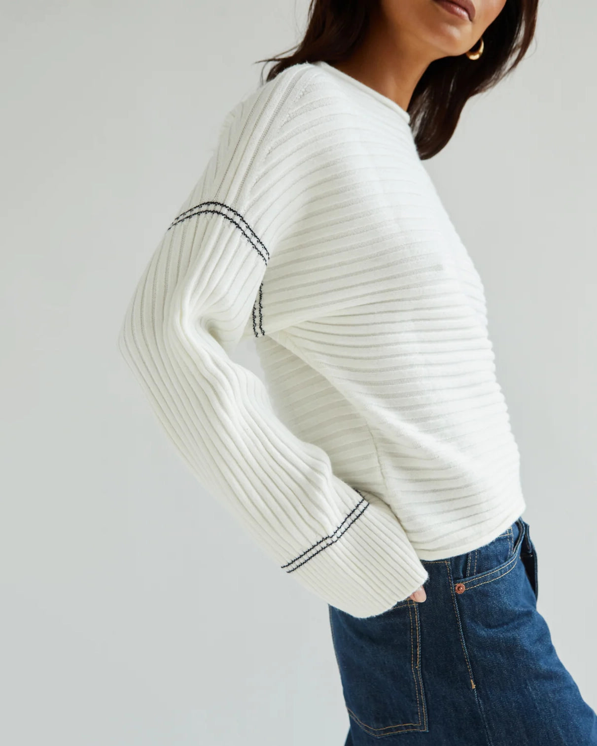 Woman wearing a white ribbed sweater