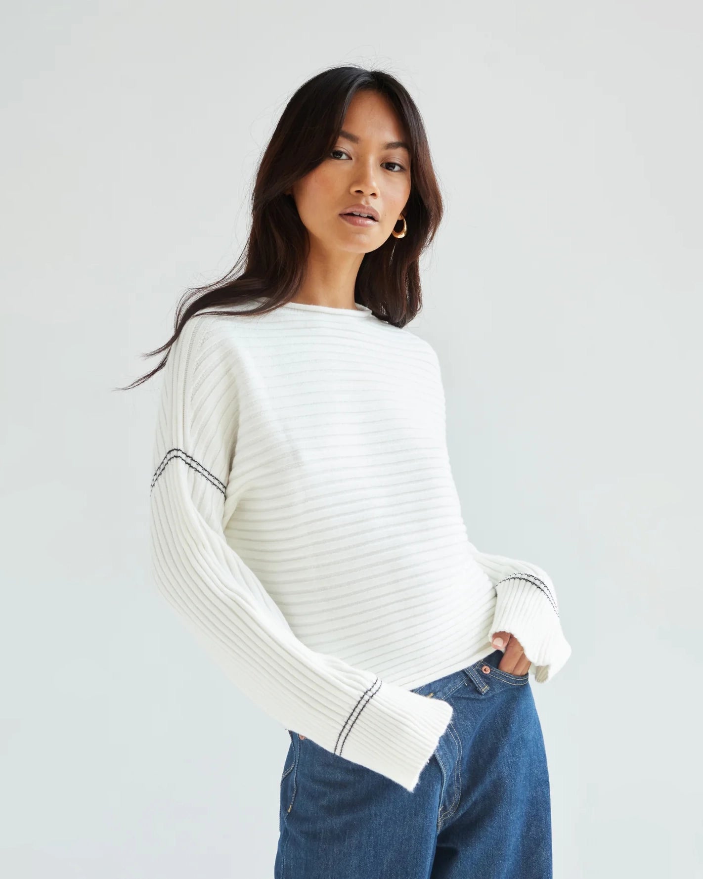 Woman wearing a white ribbed sweater