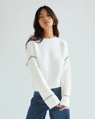 Woman wearing a white ribbed sweater