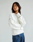 Woman wearing a white ribbed sweater