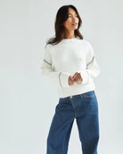 Woman wearing a white ribbed sweater