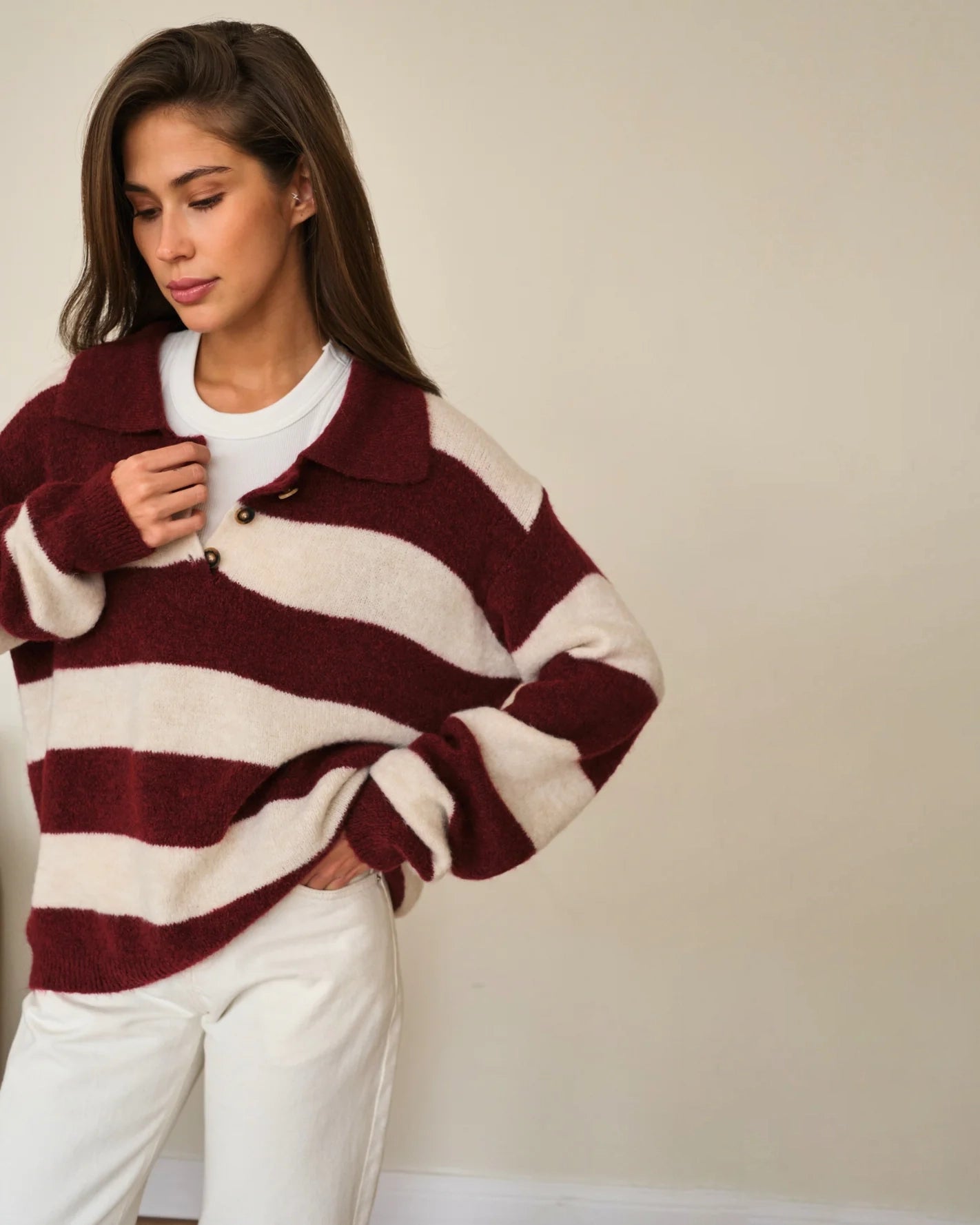 Woman wearing a maroon and white striped fluffy sweater 