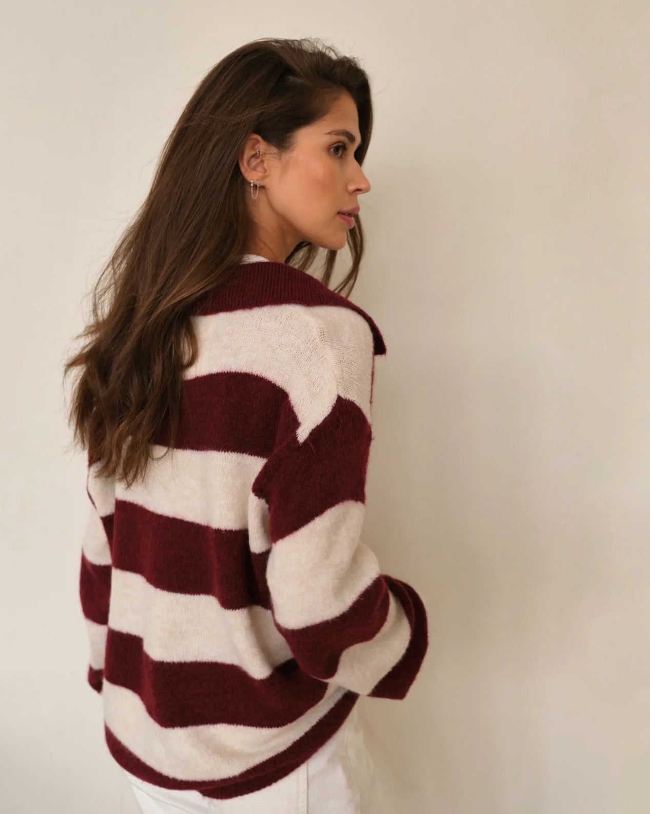 Woman wearing a maroon and white striped fluffy sweater 