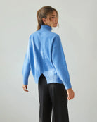 Woman wearing a relaxed fit high neck sweater in cornflower blue