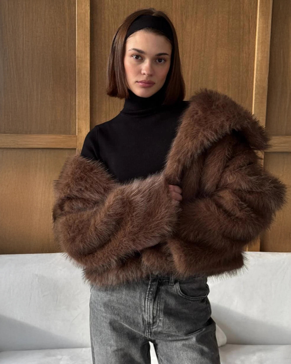 a woman wears a faux fur coat in brown with big lapels
