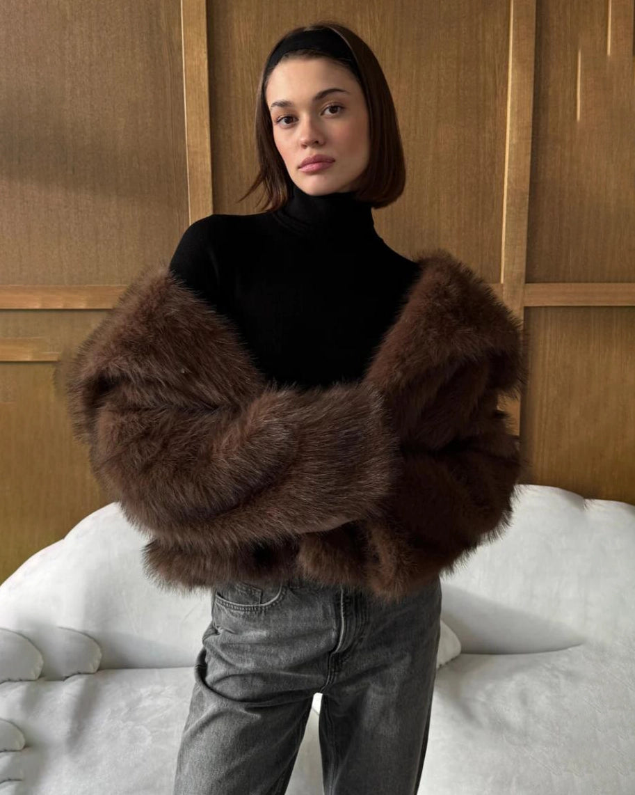 a woman wears a faux fur coat in brown with big lapels