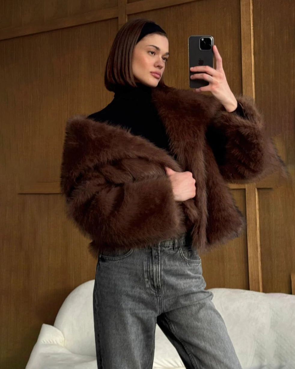 a woman wears a faux fur coat in brown with big lapels