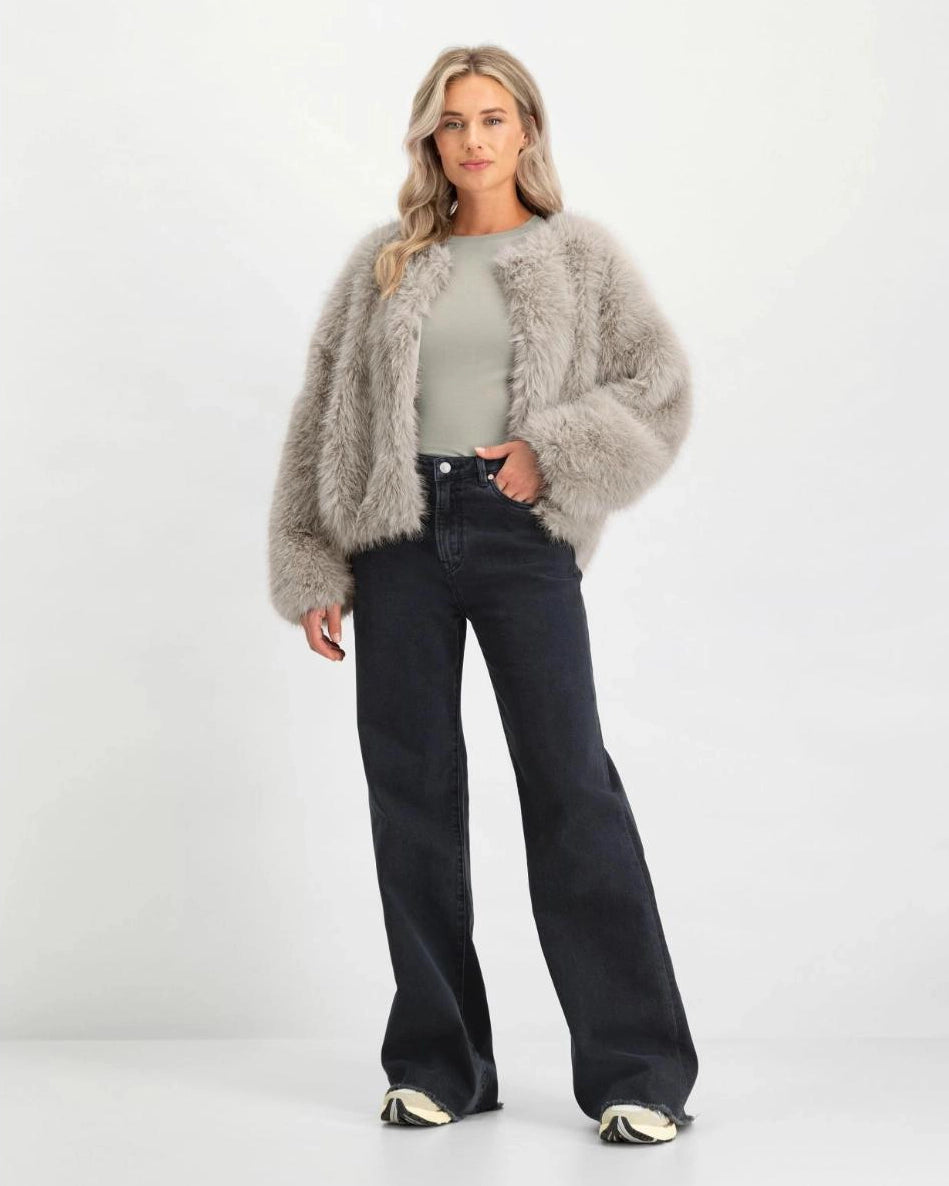 a woman wearing black flared denim jeans