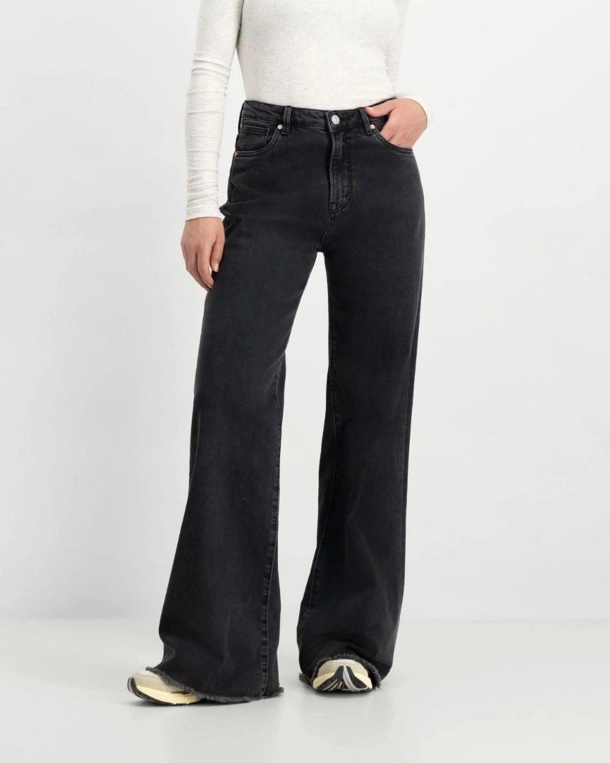 a woman wearing black flared denim jeans