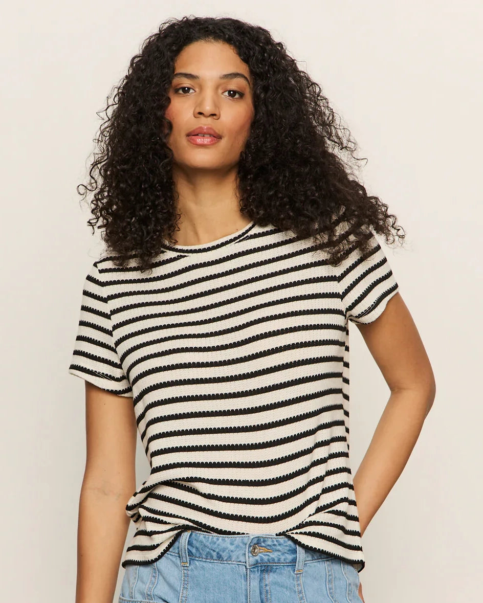 A woman wears a striped t-shirt in navy and cream