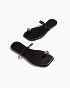 black sandal with gold toe piece 