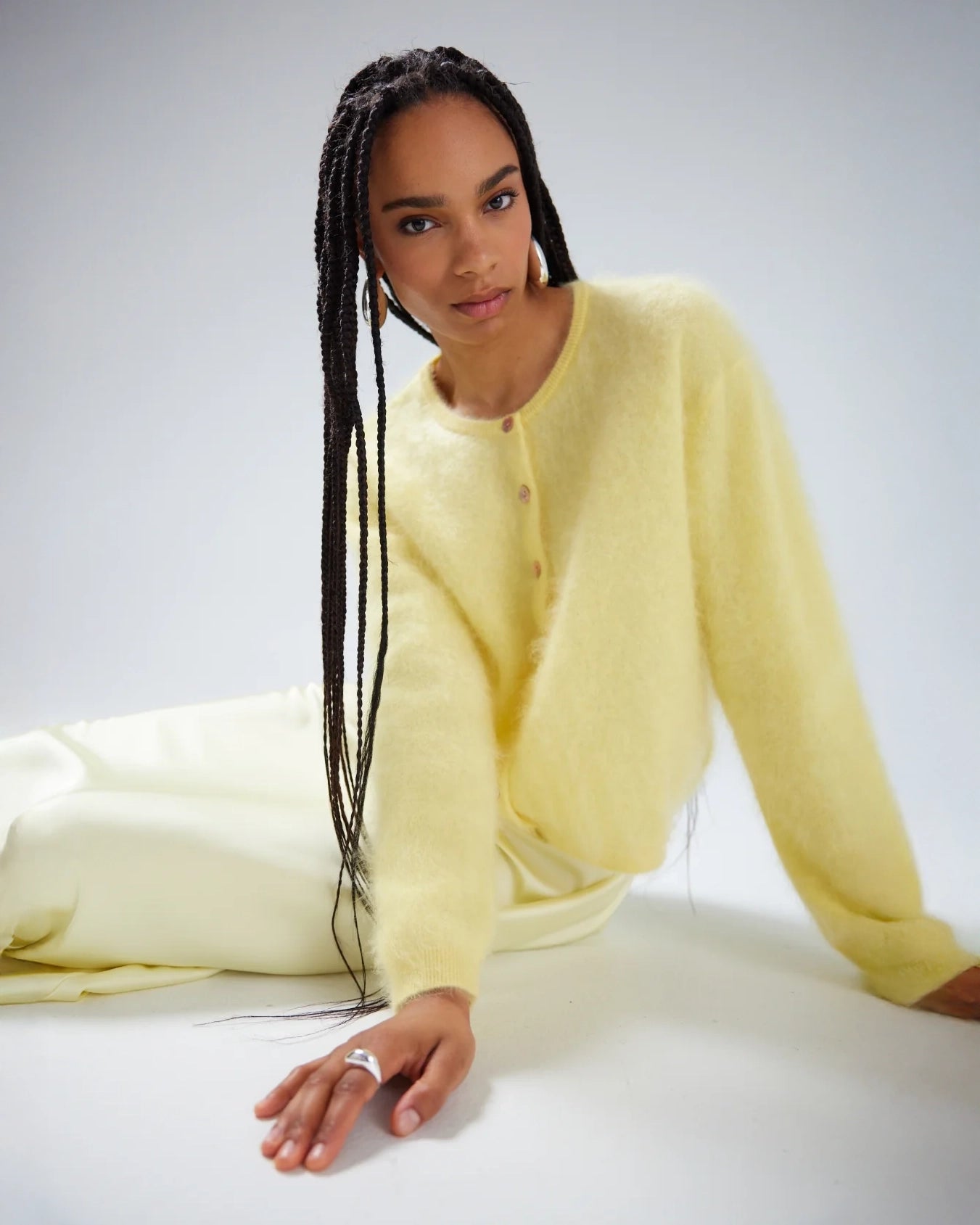 Woman wearing a light yellow brushed cashmere button down cardigan