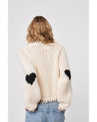 cream sweater with black heatrs all over