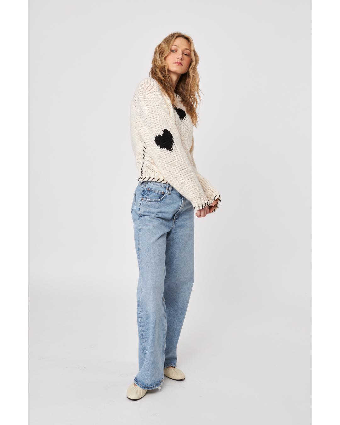 cream sweater with black heatrs all over