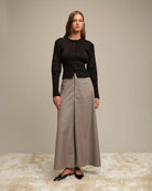 Woman wearing a black ribbed button down cardigan and beige wide-leg pants
