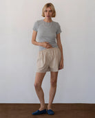 Person wearing beige cotton boxer shorts with grey t-shirt