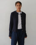 a woman wearing a dark navy blue ribbed button down cardigan 