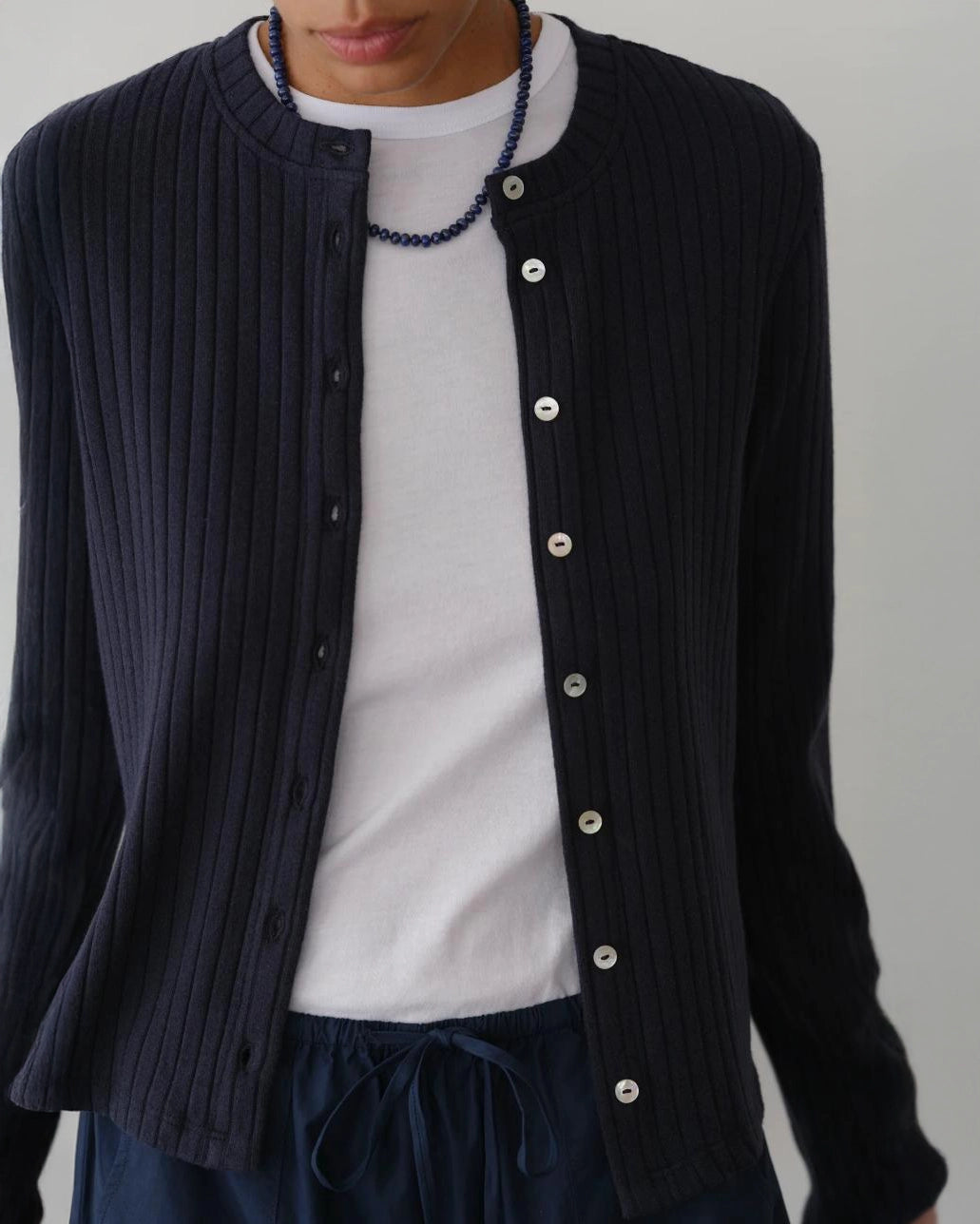 a woman wearing a dark navy blue ribbed button down cardigan 