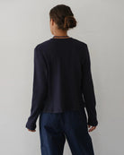 a woman wearing a dark navy blue ribbed button down cardigan 