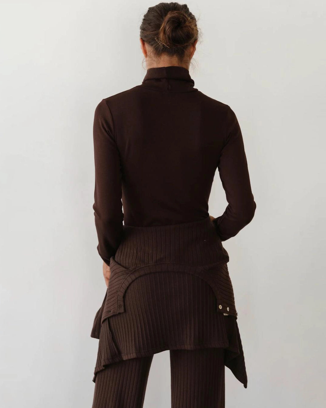 Woman wearing a brown turtleneck rib top 