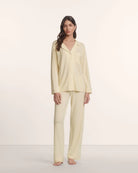 Woman wearing a light yellow pajama set 