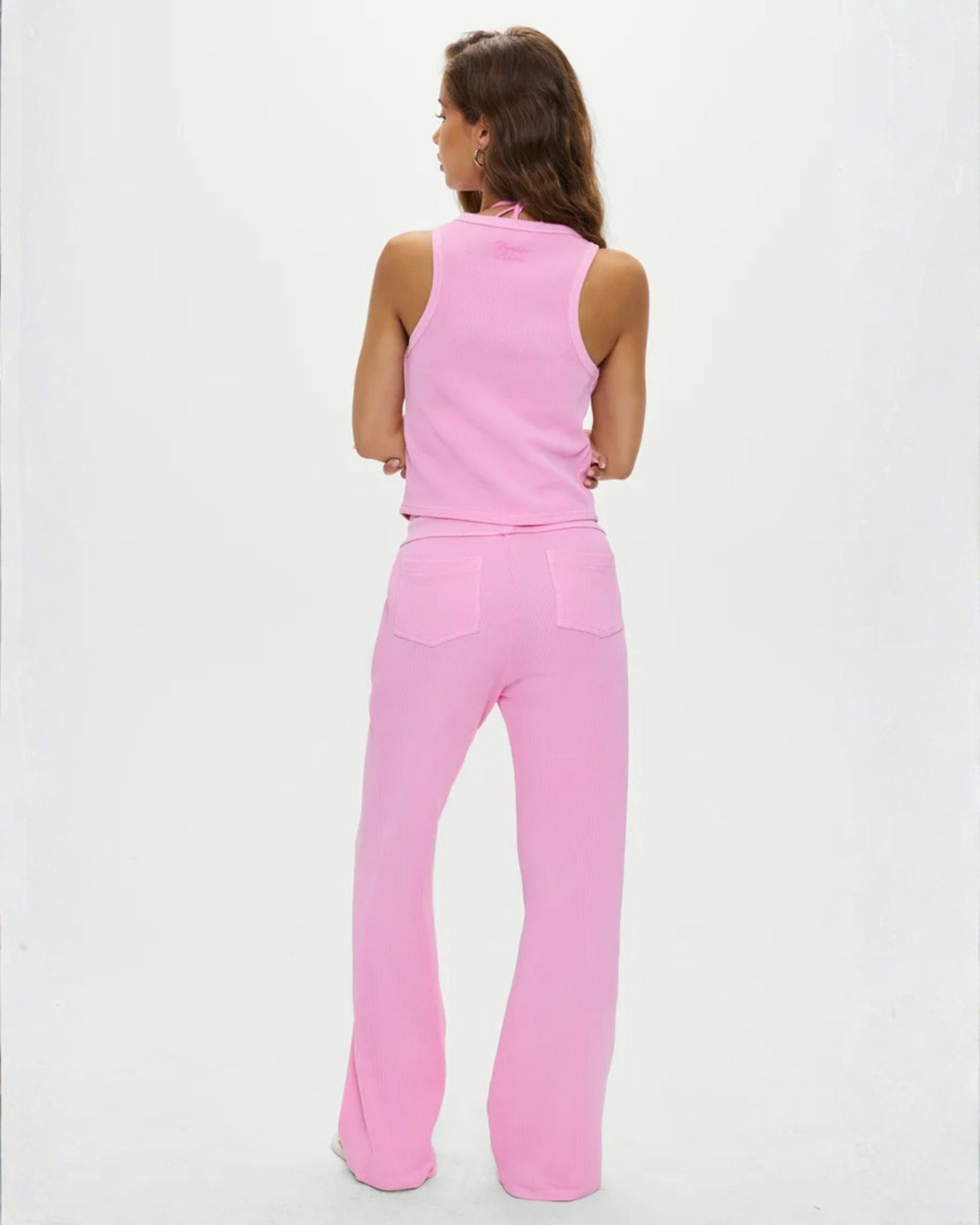 a woman is wearing waffle knit joggers in neon pink by Frankies Bikinis