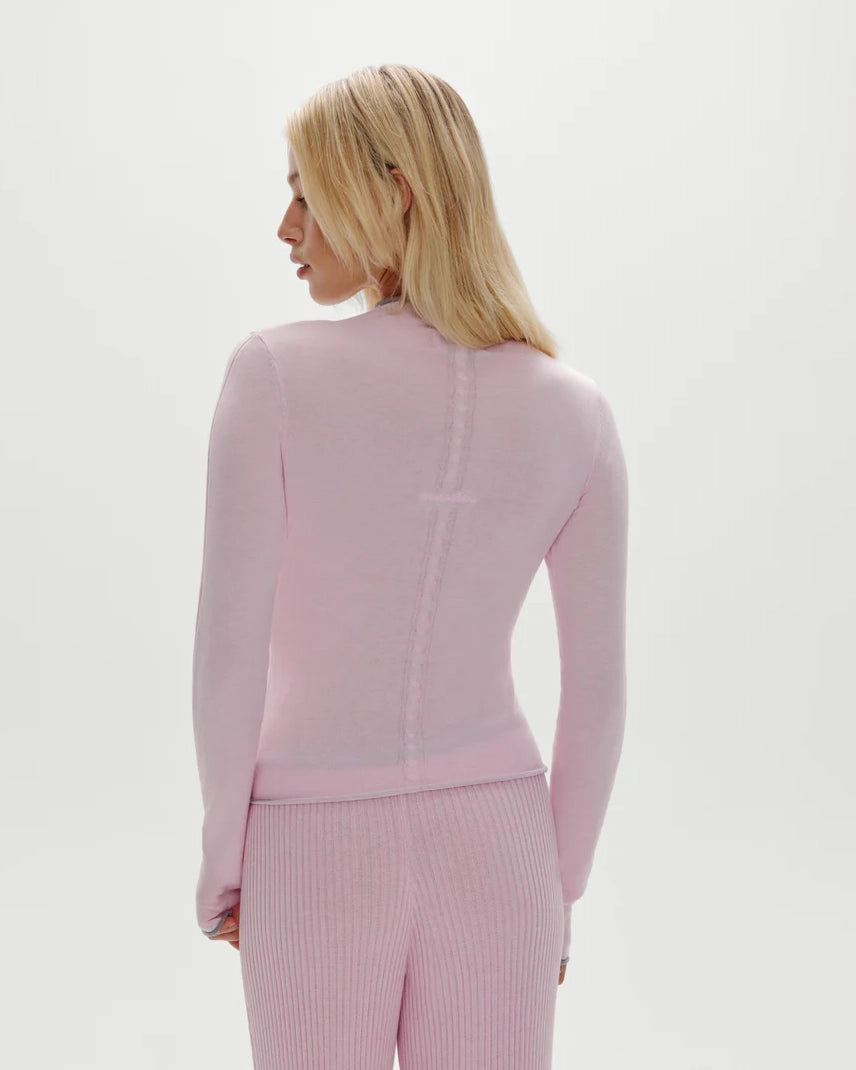 Woman wearing a pink ribbed long-sleeve button down top with grey trim and matching pants