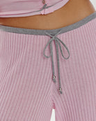 A close up of a pink ribbed lounge pant with grey drawstring and trim