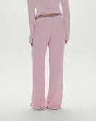 A woman wearing a pink ribbed lounge pant with grey drawstring and trim