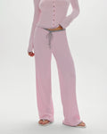 A woman wearing a pink ribbed lounge pant with grey drawstring and trim