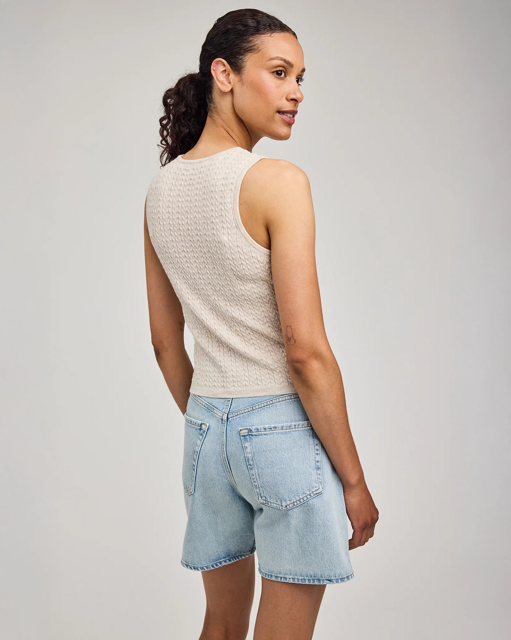 Woman wearing a beige sleeveless knitted top by Gentle Dawn