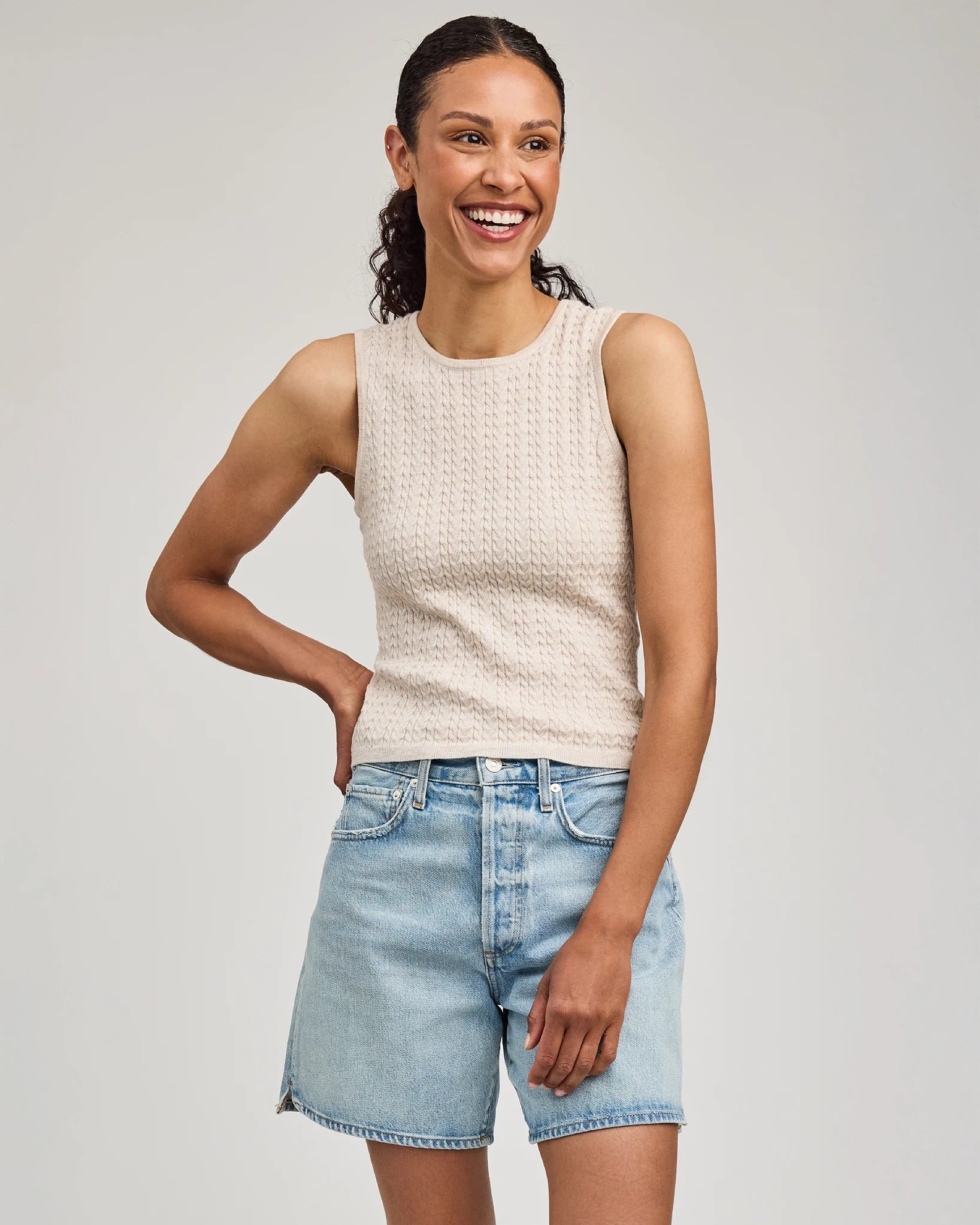 Woman wearing a beige sleeveless knitted top by Gentle Dawn