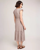 woman wearing linen dress with tiered skirt and  burgundy stripe 