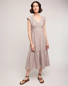 woman wearing linen dress with tiered skirt and  burgundy stripe 