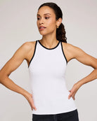 Woman wearing a white tank top with black trim