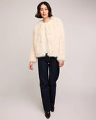 woman wearing a faux fur jacket in cream