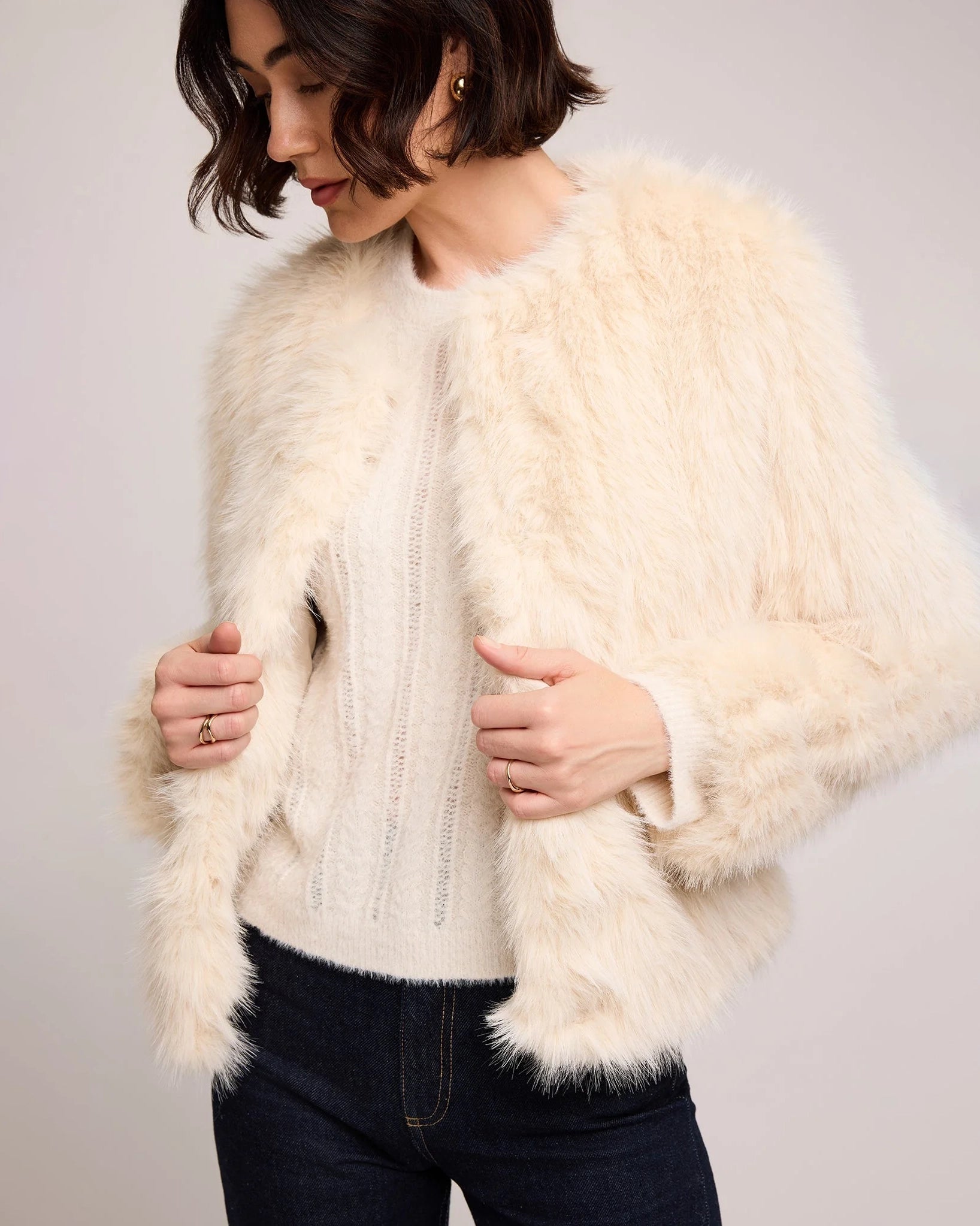 woman wearing a faux fur jacket in cream
