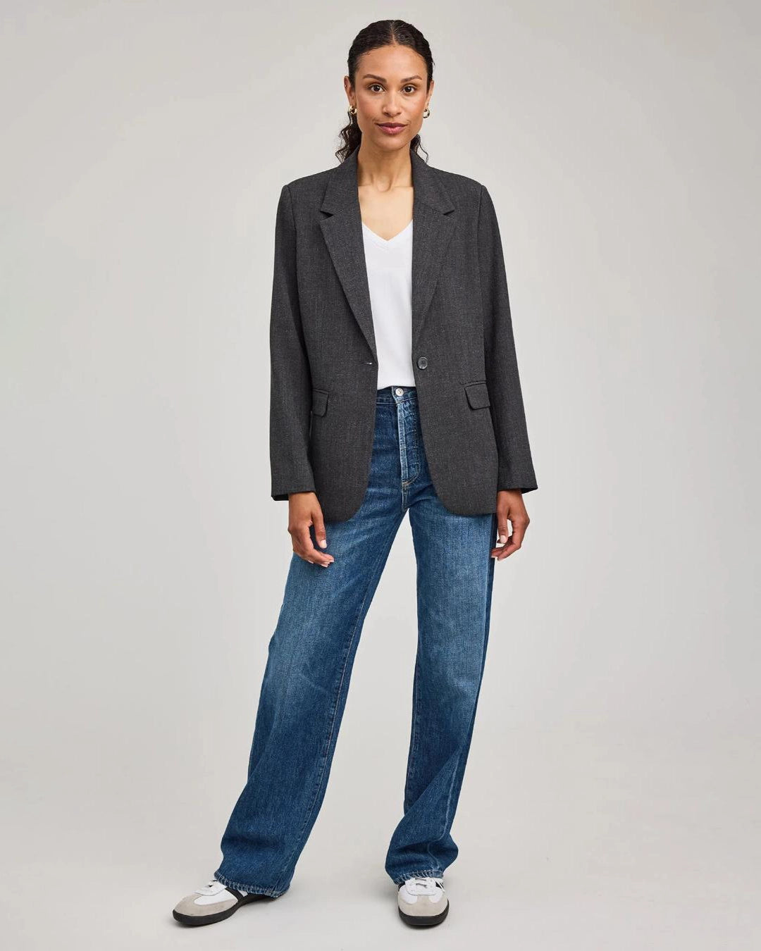 Woman wearing a gray blazer with one single button with jeans