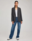 Woman wearing a gray blazer with one single button with jeans