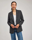 Woman wearing a gray blazer with one single button