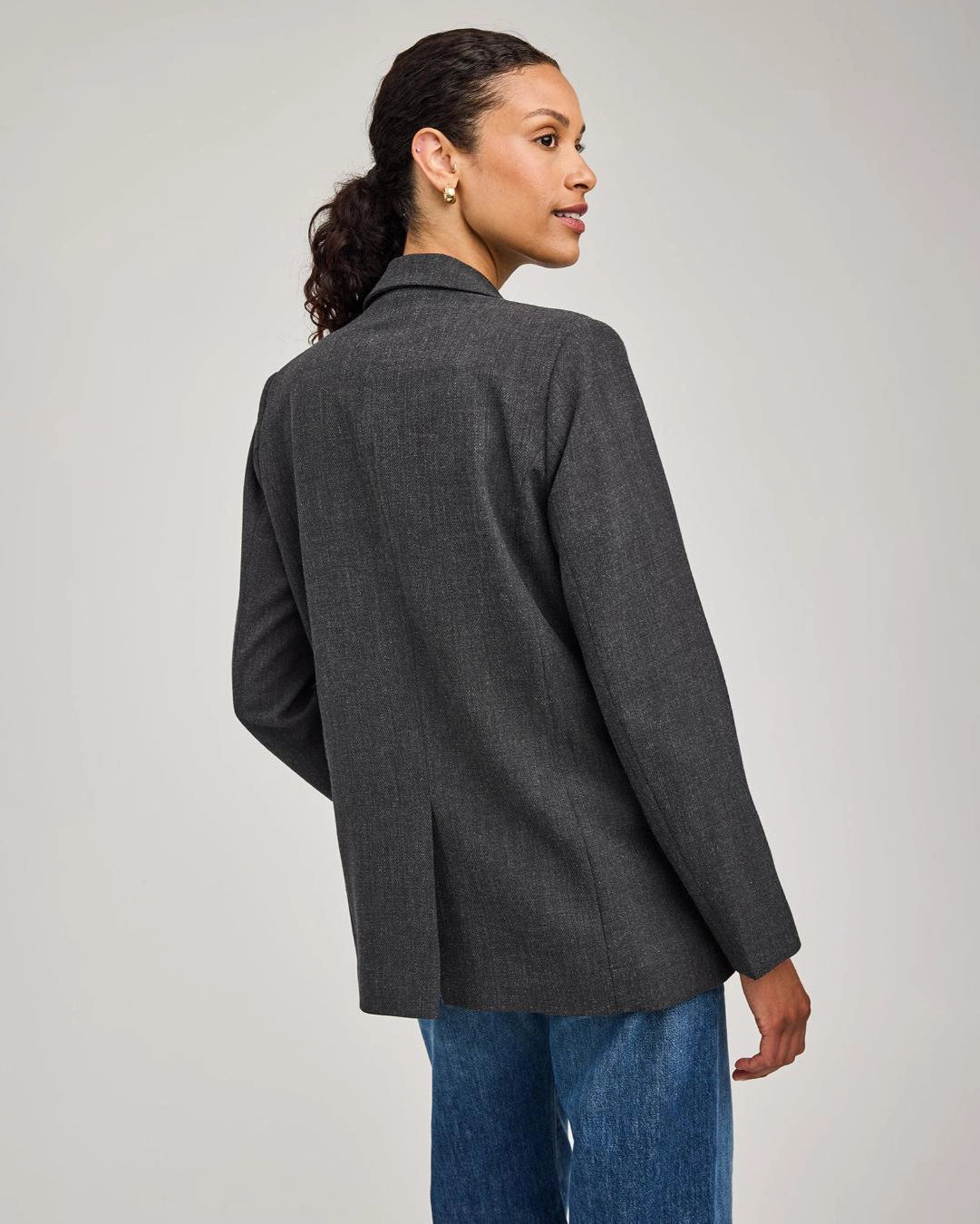 Woman wearing a gray blazer with one single button