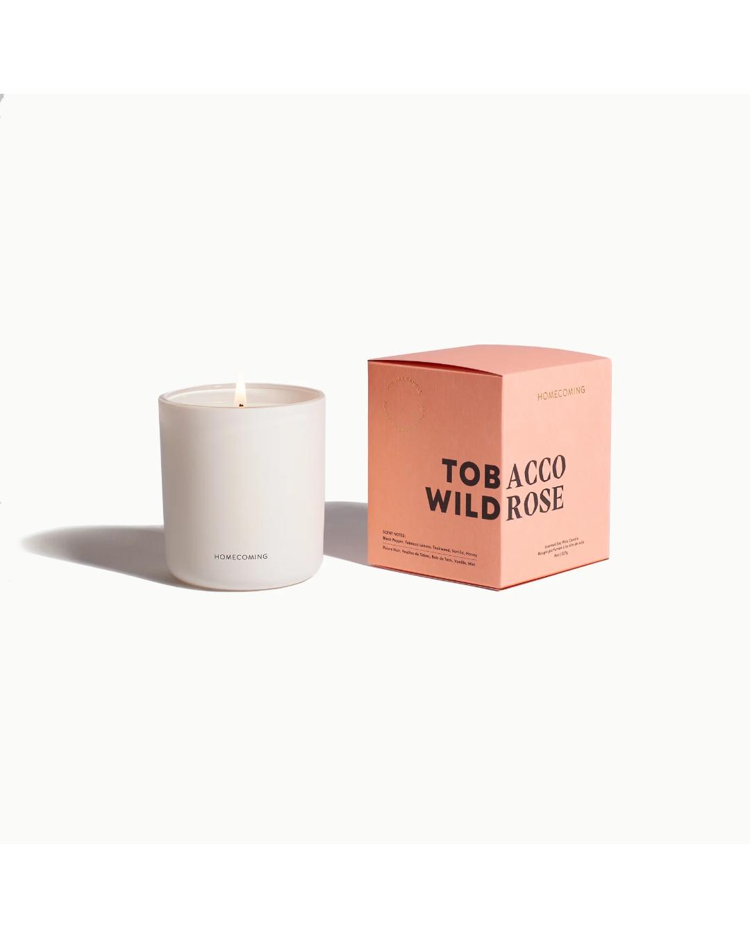 white candle next to a pink box