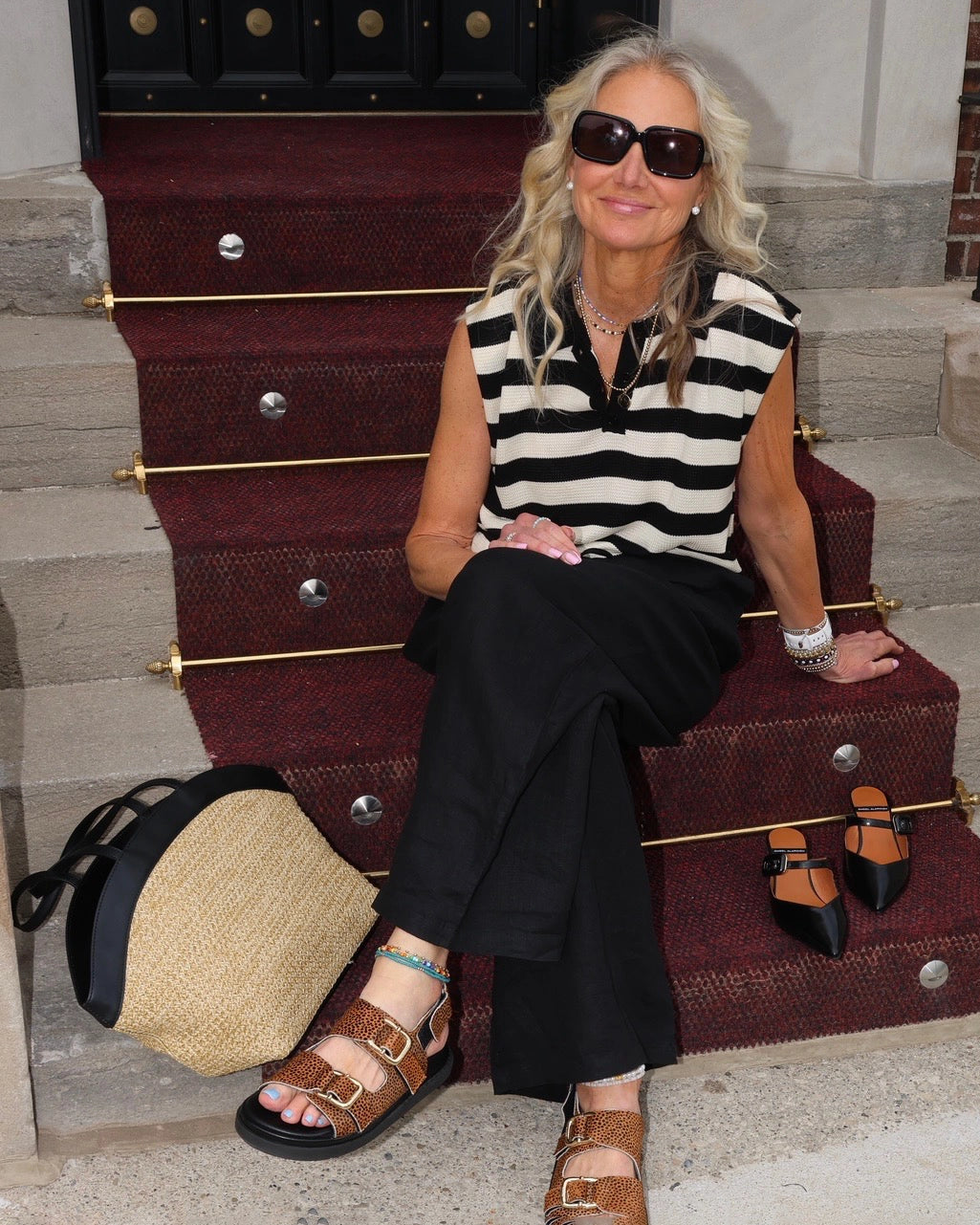 Woman wearing a black and white striped sleeveless knit top