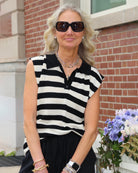 Woman wearing a black and white striped sleeveless knit top