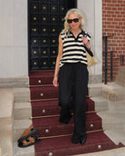 Woman wearing a black and white striped sleeveless knit top