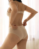 Woman wearing a beige bra and beige hipster boyshort underwear made from tencel