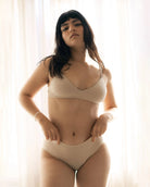 Woman wearing a beige bra and beige hipster boyshort underwear made from tencel