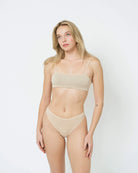 Woman in a beige bandeau sports modal bralette and undies