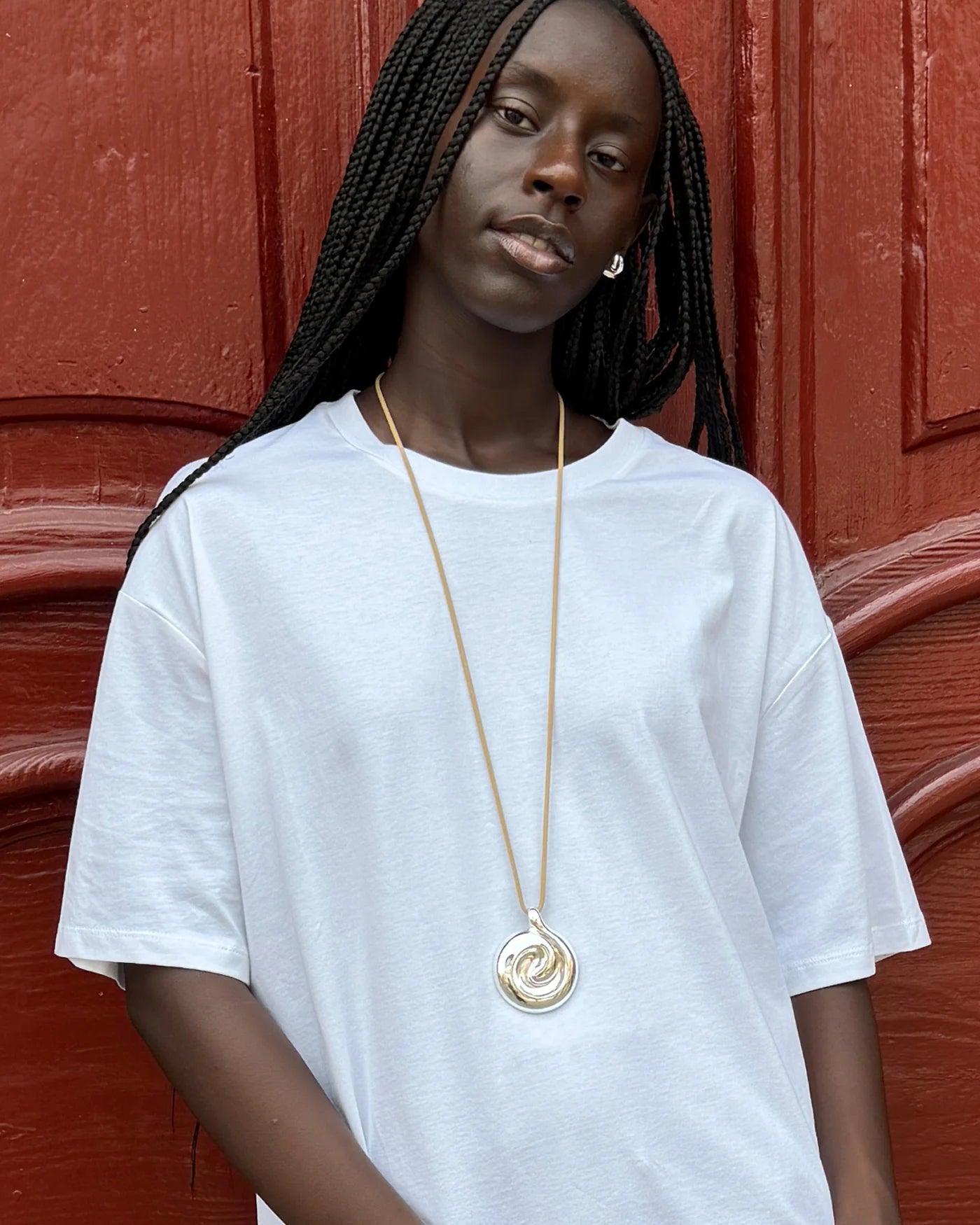 tan cord necklace with a chunky silver pendant 